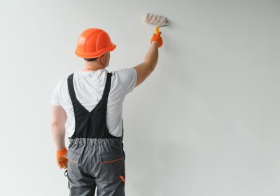 Painter man painting the wall in home, with paint roller and white color paint. Painter man painting the wall in home, with paint roller and white color paint.